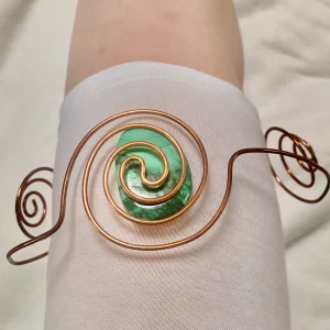 Spirale porte-cristal en cuivre enroulée autour d’une pointe de cristal de roche – création énergétique artisanale