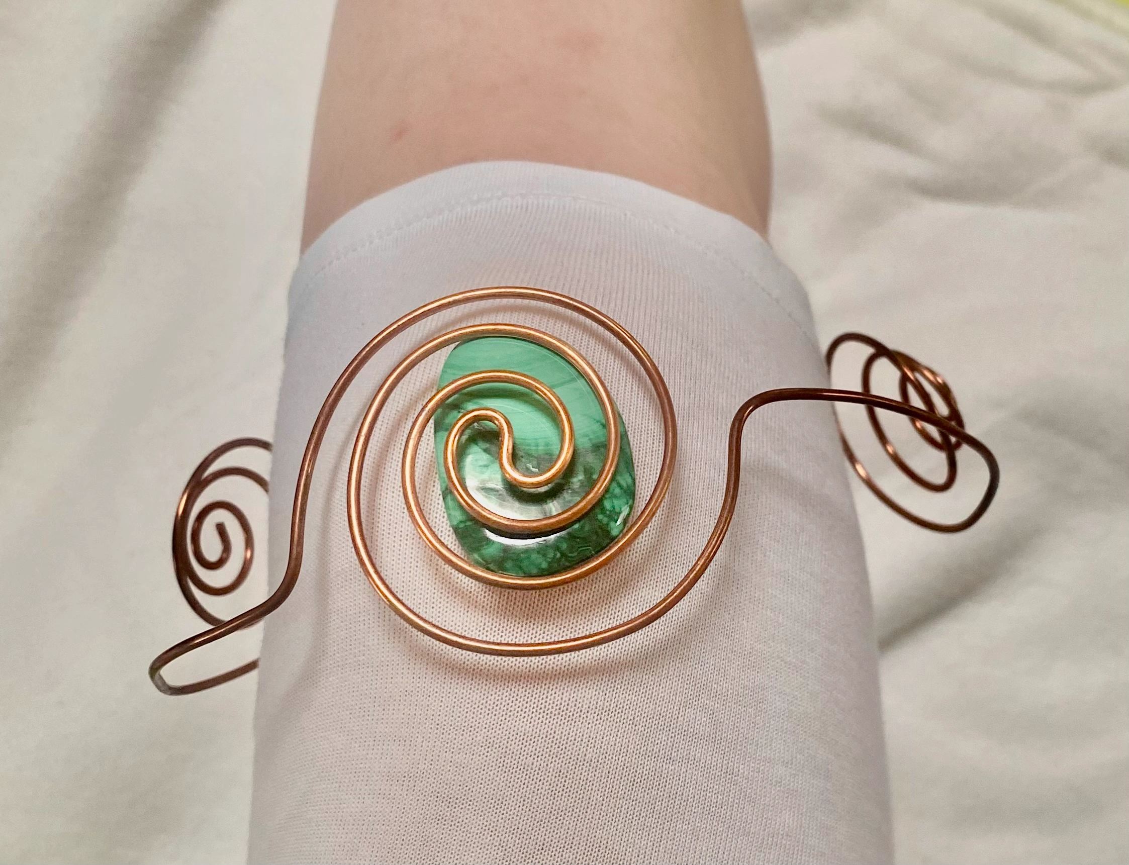 Spirale porte-cristal en cuivre enroulée autour d’une pointe de cristal de roche – création énergétique artisanale
